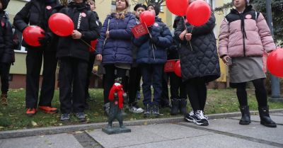 Figurki niedźwiadków i miejskie rzeźby z czerwonymi szaliczkami w Białymstoku w ramach akcji "Dzieciństwo bez przemocy"